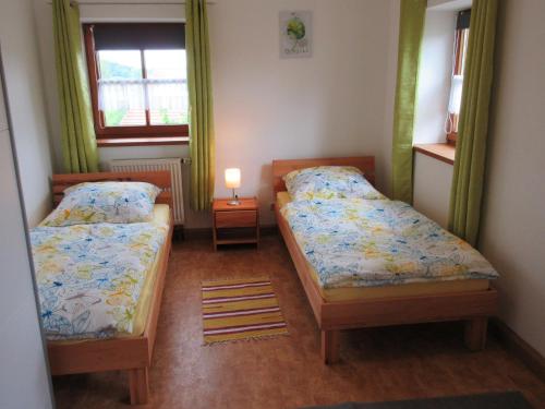 ein Schlafzimmer mit 2 Betten und einer Lampe in der Unterkunft Ferienhaus am Waginger See in Kirchanschöring