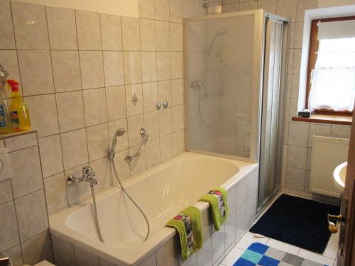 ein Bad mit einer Badewanne, einer Dusche und einem Waschbecken in der Unterkunft Ferienhaus am Waginger See in Kirchanschöring