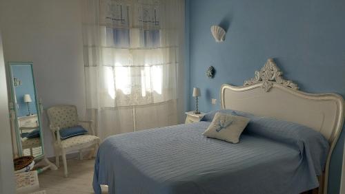 um quarto azul com uma cama e uma janela em APPARTAMENTO AZZURRO FRONTE MARE em San Vincenzo