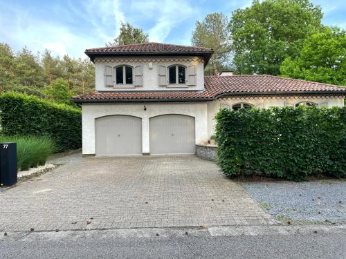 a large white house with two garage doors at B&B Monroe in Averbode