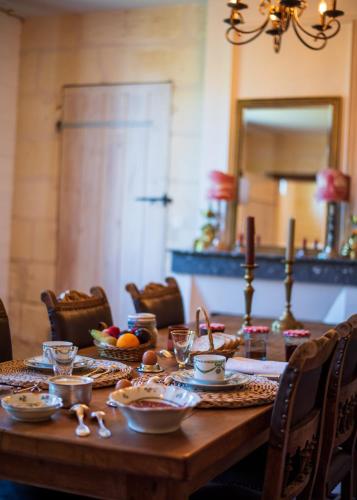 Chambre Merlot, piscine et spa, proche St Emilion في Lugon et l’Ile du Carney: طاولة خشبية عليها طعام