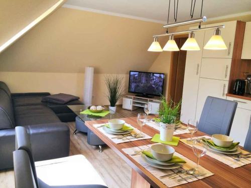 ein Wohnzimmer mit einem Tisch und einem Sofa in der Unterkunft Haus der Seeadler - Appartementhaus Haus der Seeadler - Fewo 4 in Borchtitz