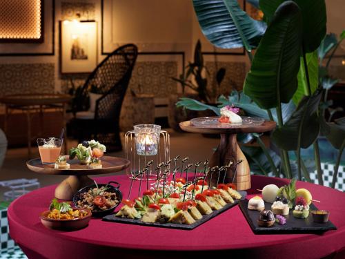 a table with several plates of food on a red table at H10 Casa de la Plata in Seville