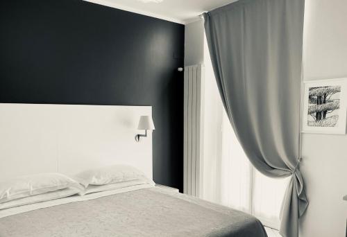 a bedroom with a white bed and a window at Albergo Belsoggiorno in Sanremo