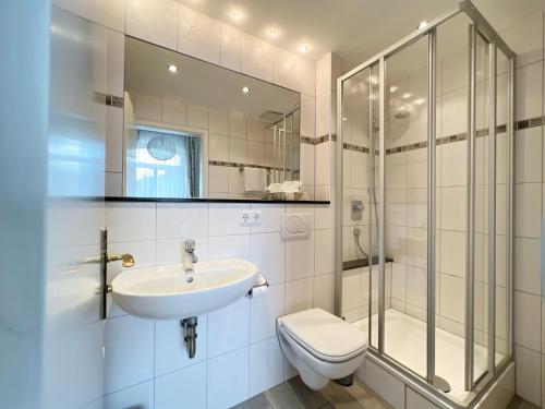 La salle de bains est pourvue d'un lavabo, de toilettes et d'une douche. dans l'établissement Hotel Kühler Krug, à Fribourg-en-Brisgau