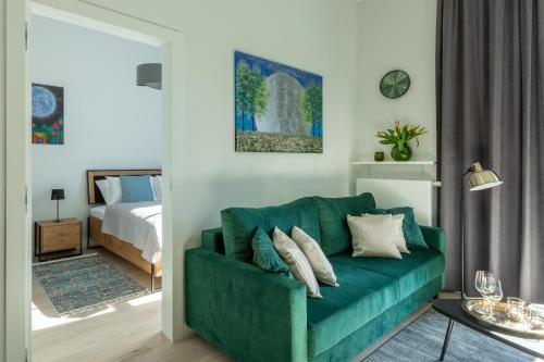 a living room with a green couch and a bed at Apartament Księżycowy - Młyn Maria - Art Apartments in Wrocław