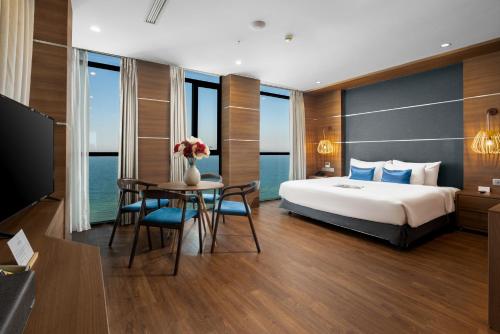 峴港的住宿－海安海灘Spa酒店，酒店客房带一张床、一张桌子和椅子