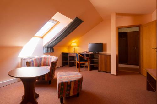 a room with a table and chairs and a television at Hotel Mohelnice in Mohelnice