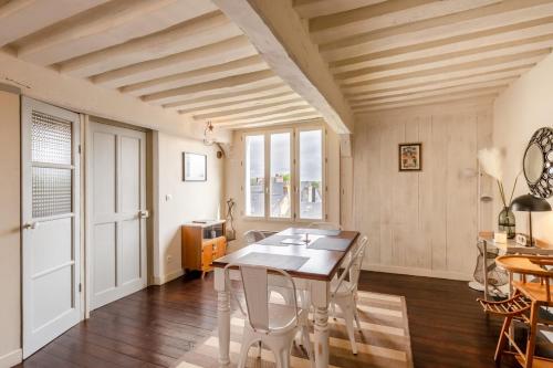 une salle à manger avec une table et des chaises blanches dans l'établissement Le Jardin d'Eugene - Maison 4P - Terrasse - Centre Historique, à Honfleur