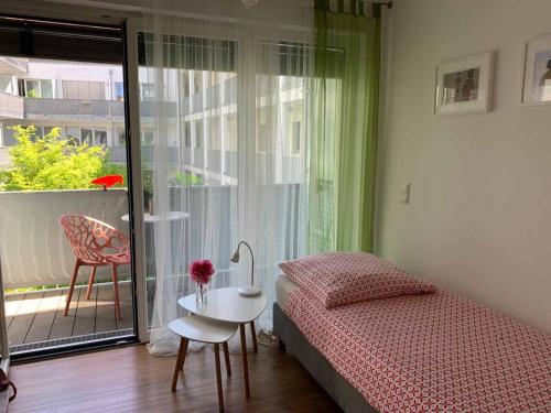 a bedroom with a bed and a table and a window at Ferienwohnungen Wolke in Regensburg