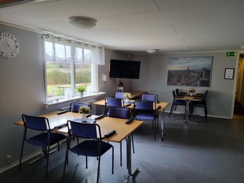 a meeting room with tables and chairs and a tv at Nyckelbo Vandrarhem in Helsingborg