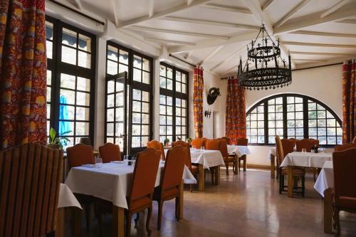 ラ・マレーヌにあるHôtel-Restaurant Le Manoir De Montesquiouのダイニングルーム(テーブル、椅子、シャンデリア付)