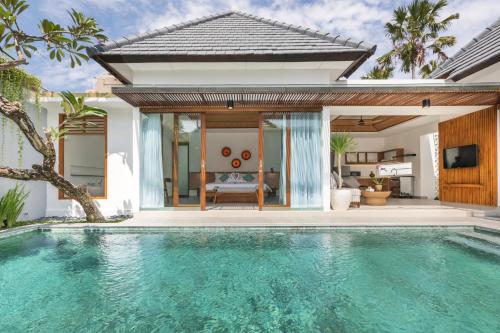 a swimming pool in front of a villa at Fenosa Seminyak Villas by Nagisa Bali in Seminyak