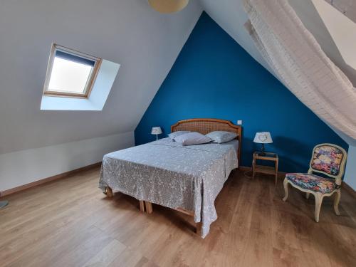 a blue bedroom with a bed and a chair at Les Gîtes Mina in Mosnes