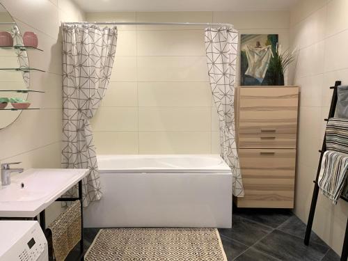 ein Badezimmer mit einer Badewanne und einem Waschbecken in der Unterkunft Sunset Residence - 5 min to the beach! in Narva-Jõesuu