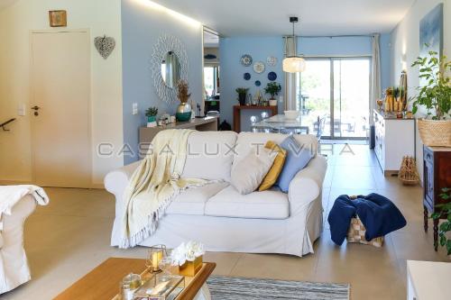 a living room with a white couch and a kitchen at Casa Lux Tavira in Luz de Tavira