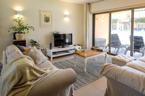 a living room with a couch and a tv at Casa Lux Tavira in Luz de Tavira