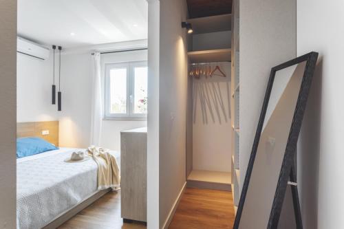 a small bedroom with a bed and a mirror at Center apartment Golden Ray in Bol