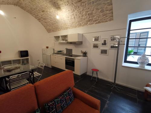 sala de estar con sofá y cocina en Aracoeli 20, en Cassano delle Murge