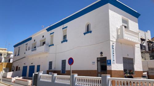 a white building with blue accents on a street at Tranvía Beach House in Chipiona