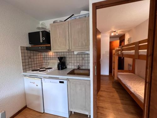 une petite cuisine avec un évier et une cuisinière dans l'établissement LA RESIDENCE 2-234 - Proche centre du village avec garage, à La Clusaz