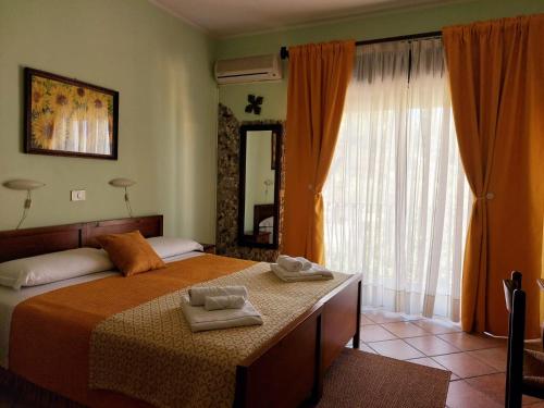 a bedroom with a bed with two towels on it at Sole Mare B&B in Giardini Naxos