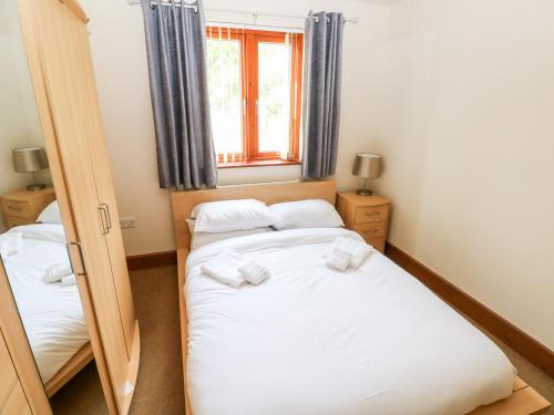 a small bedroom with two beds and a mirror at 15 Sovereign House in Milford Haven