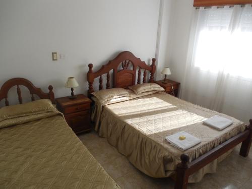 a bedroom with two beds and a window at Victor Hotel in Villa Carlos Paz