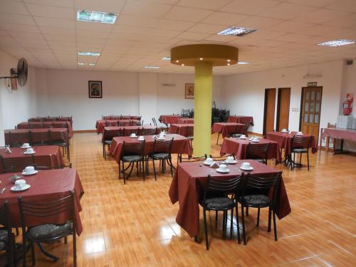 a restaurant with red tables and chairs in a room at Victor Hotel in Villa Carlos Paz