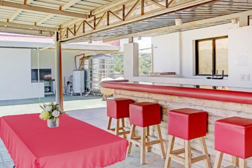 ZambalesにあるOYO 869 Jnv Dream Hotelの赤いテーブルと赤い椅子が備わるレストラン