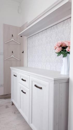 a white cabinet with a vase of flowers on it at Penzion HARMONIE in Trhové Sviny