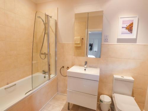 Un baño con ducha, inodoro y lavabo. en Edencroft, en Penrith
