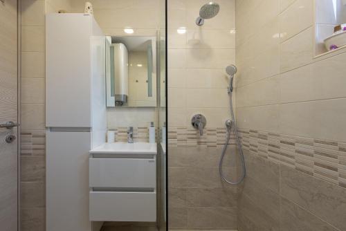 y baño con ducha y lavamanos. en R&B Family Apartments, en Sveti Filip i Jakov