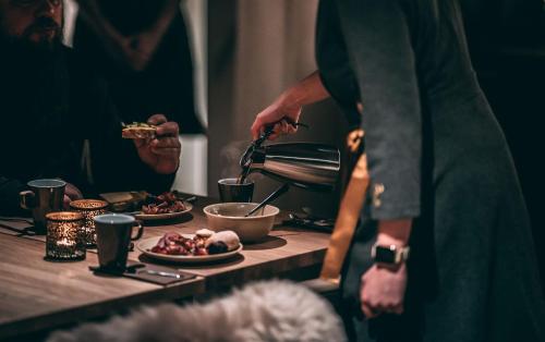 a group of people standing around a table with food at Lapland Hotels Arena in Tampere