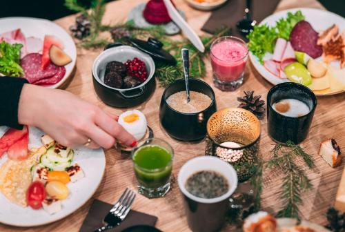a wooden table with plates of food on it at Lapland Hotels Arena in Tampere