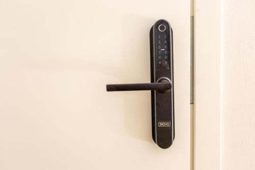 a black remote control hanging on a door at B2 Apartments in Klaipėda