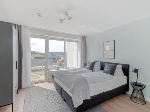 a bedroom with a large bed and a large window at Limehome Wolfsburg Porschestraße in Wolfsburg