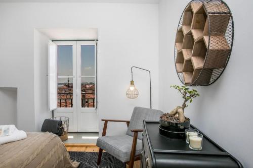 a bedroom with a bed and a table with a chair at Santo Estevão by SpotOn Apartments in Lisbon