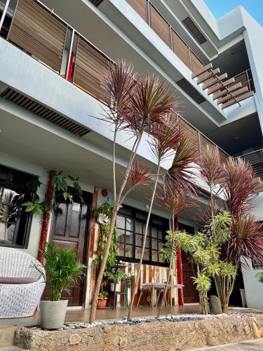 a building with palm trees in front of it at Hostel Privado in Puerto Princesa City