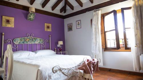 EstradaにあるFuente De Las Anjanasのベッドルーム1室(紫の壁のベッド1台、窓付)