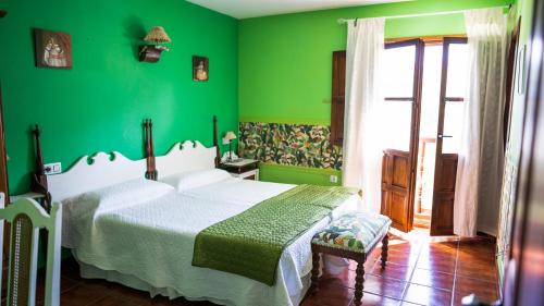 a green bedroom with a bed and a green wall at Fuente De Las Anjanas in Estrada
