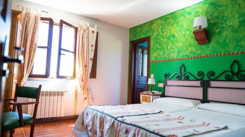 a bedroom with a bed with a green wall at Fuente De Las Anjanas in Estrada