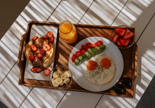 a tray of food with a plate of eggs and fruit at Akrorama private villas and suites in Akrotiri