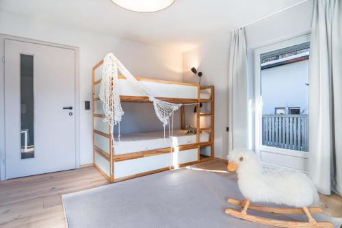 une chambre avec un lit bébé et un poulet jouet sur un tapis dans l'établissement Mami Fee Familien Ferienhaus Hopfgarten, à Hopfgarten im Brixental
