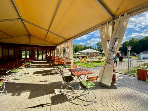 a group of tables and chairs under a tent at Ölmühle Eberstedt in Eberstedt