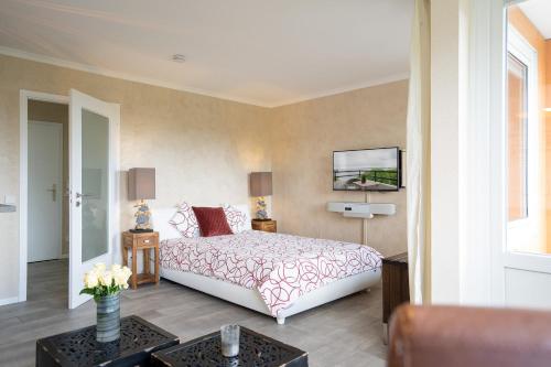 1 dormitorio con 1 cama y TV en la pared en Deluxe Quartier am Plöner See - Hallenbad kostenlos, en Plön