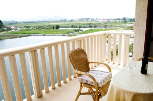 a table and chair on a balcony with a view of the water at Comfortable and beautiful apartment in Ploče