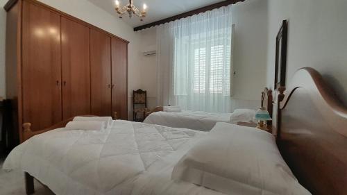 a bedroom with two beds and a large window at Welcomely - Janas de Ilu in Mamoiada