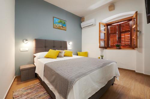 a bedroom with a large bed with yellow pillows at TOMY - KATY in Trogir