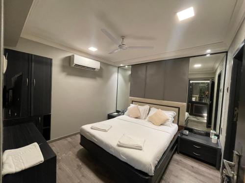 a bedroom with a bed with white sheets and pillows at Gulf Hotel Mumbai- The Boutique Hotel Colaba Mumbai in Mumbai